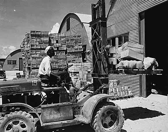 M. D. Shore, S1/c, operating a forklift truck at the Navy supply depot at Guam, Marianas. 06/08/1945.