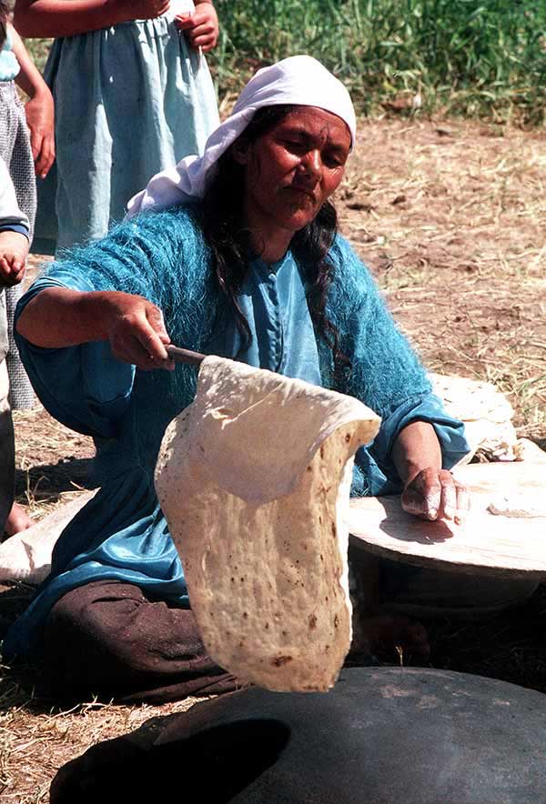 A Kurdish woman makes unleavened bread in a tent city set up by Allied forces as part of Operation Provide Comfort, an effort to aid the refugees who fled the forces of Saddam Hussein in northern Iraq.
